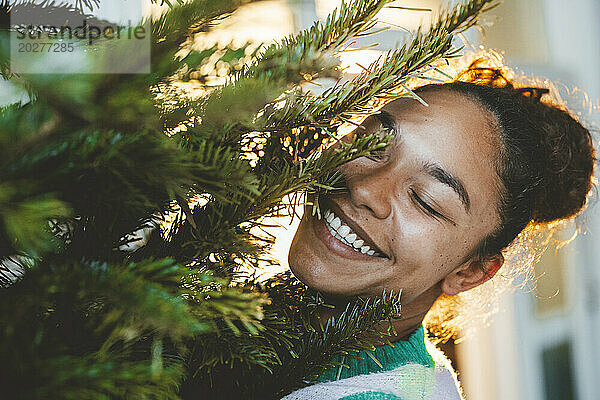 Glückliche junge Frau am Weihnachtsbaum