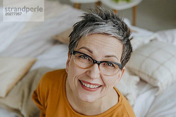 Lächelnde Frau mit Brille zu Hause