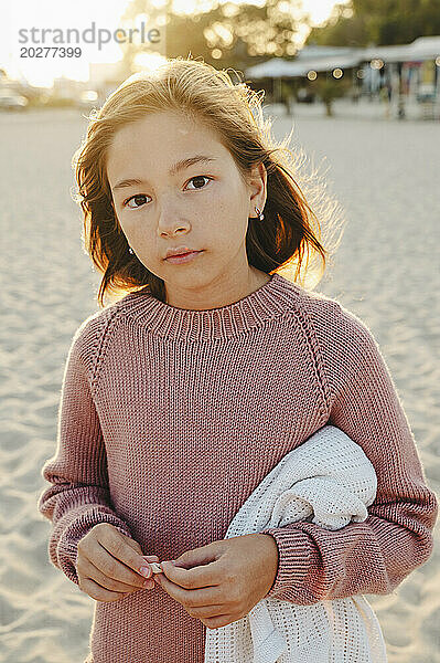 Girl wearing knitted sweater at sunset