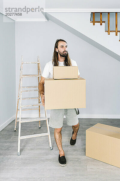 Mann trägt Kartons im neuen Zuhause