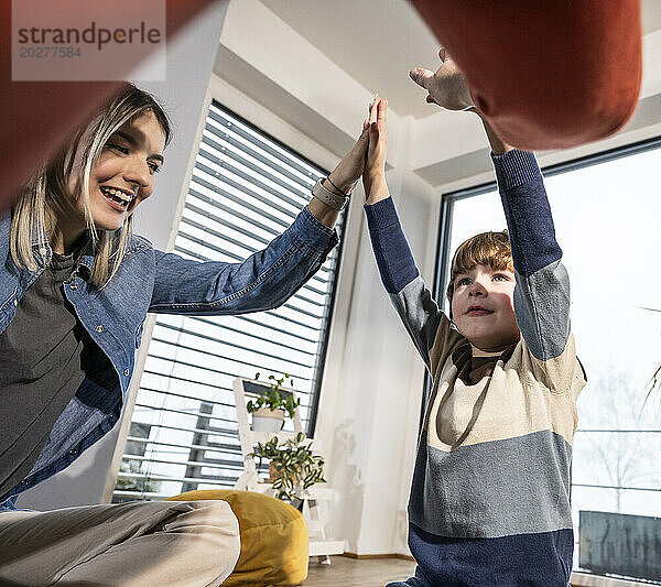 Glückliche Familie  die sich zu Hause gegenseitig High-Five gibt