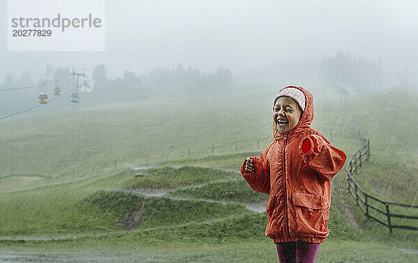 Happy girl standing in rain
