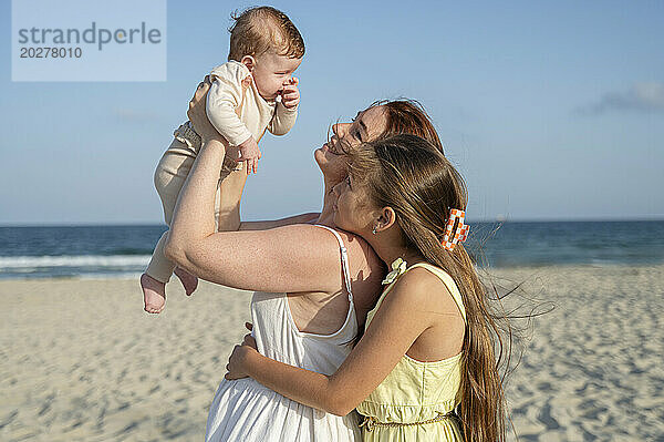 Frau verbringt Freizeit mit Töchtern am Strand