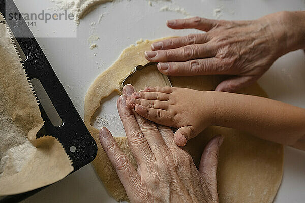 Enkel und Großmutter bereiten Kekse mit Formschneider zu