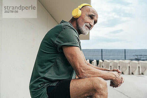 Älterer Mann hört Musik über kabellose Kopfhörer