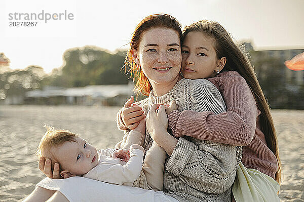 Glückliche Frau verbringt Freizeit mit Töchtern am Strand