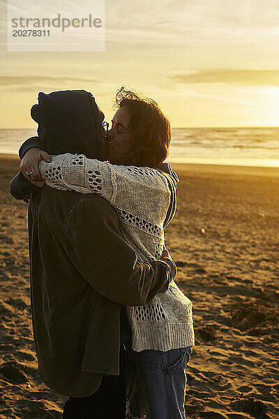 Liebespaar küsst sich am Strand