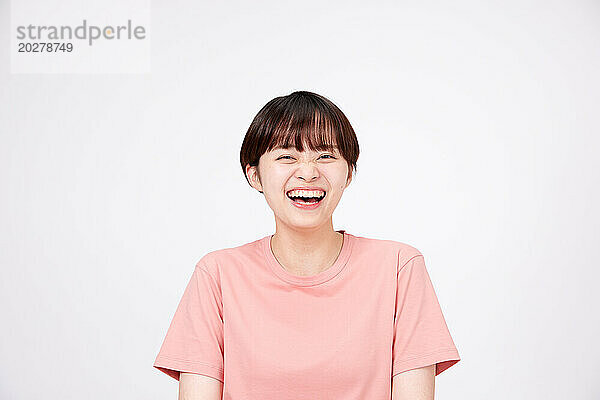 Eine Frau in einem rosa Hemd lacht