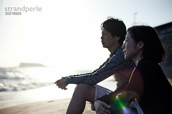 Ein Mann und eine Frau sitzen am Strand
