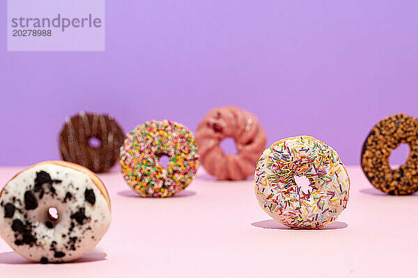 Eine Gruppe Donuts auf rosa Hintergrund