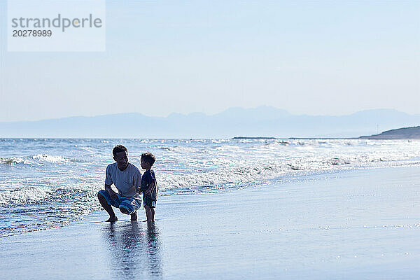 Asiatische Familie am Strand