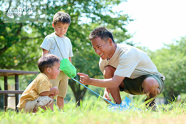 Ein Mann und Kinder spielen im Gras