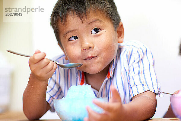 Kind isst geschabtes Eis