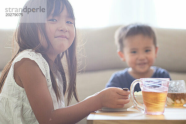 Kinder sitzen an einem Tisch und essen