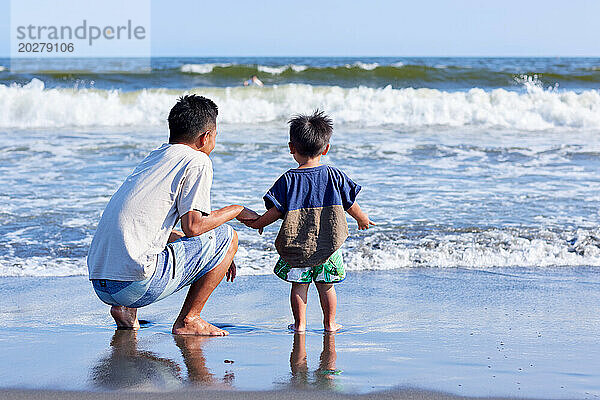 Asiatische Familie am Strand