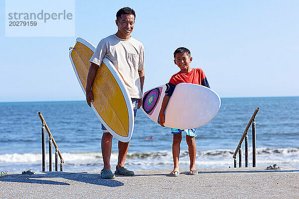 Familie mit Surfbrettern am Strand