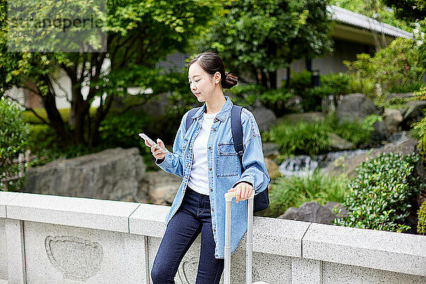 Asiatische Frau benutzt Smartphone