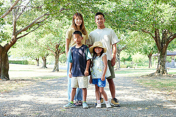 Eine Familie posiert für ein Foto in einem Park