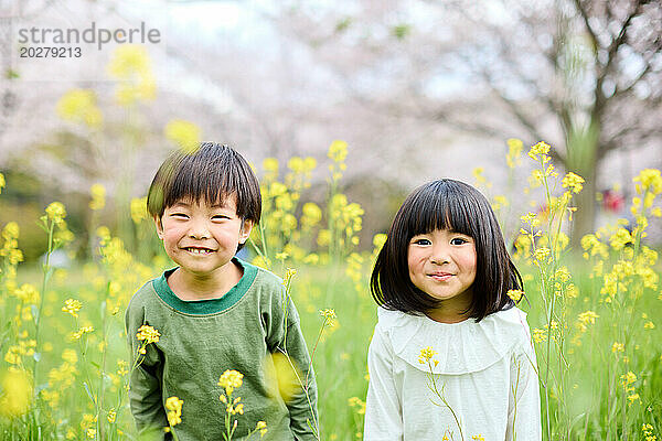 Zwei Kinder stehen auf einer Blumenwiese