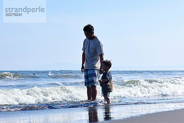 Asiatische Familie am Strand