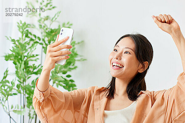 Asiatische Frau macht Selfie mit ihrem Handy