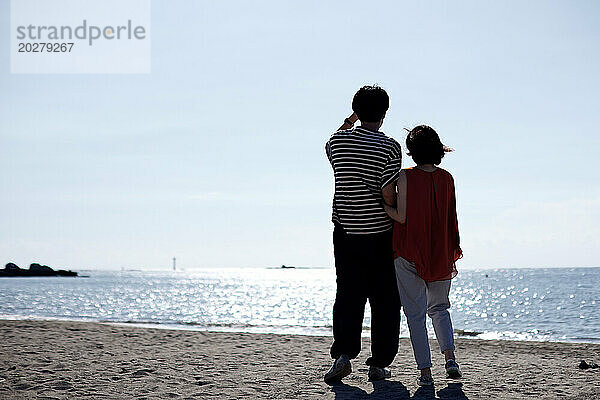 Ein Mann und eine Frau stehen am Strand