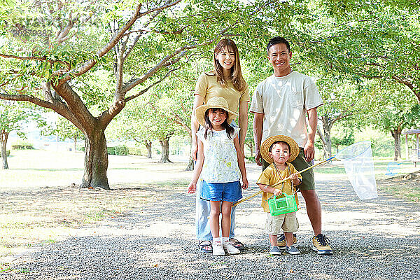 Eine vierköpfige Familie steht in einem Park