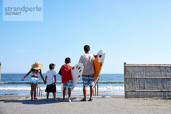 Familie mit Surfbrettern am Strand