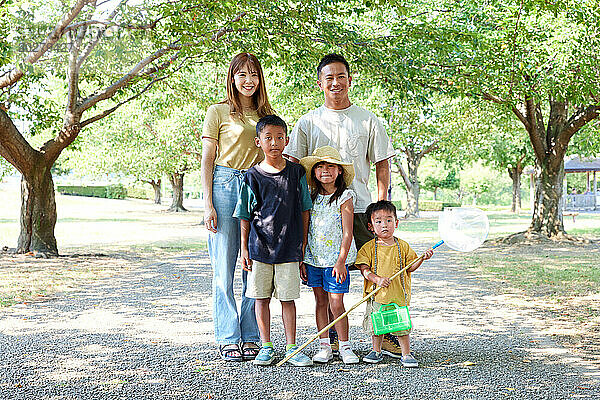 Eine Familie posiert für ein Foto in einem Park