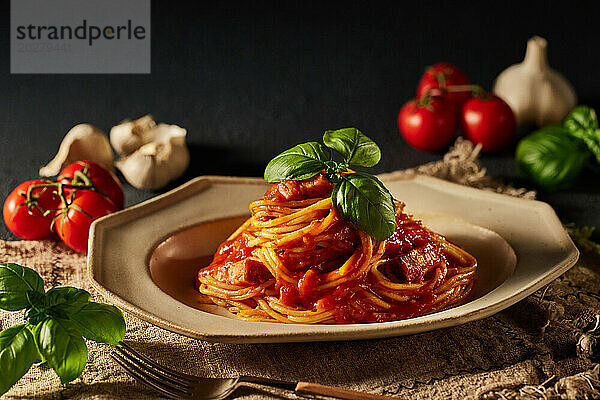 Spaghetti mit Tomatensauce und Basilikumblättern auf einem Teller