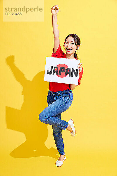 Eine Frau hält ein Schild mit der Aufschrift „Japan“.