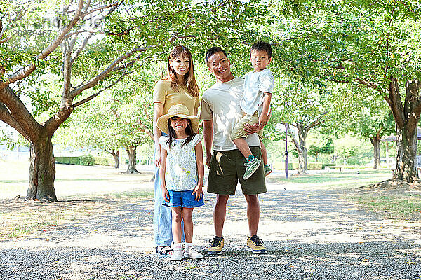 Eine Familie posiert für ein Foto in einem Park