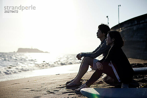 Ein Paar sitzt am Strand