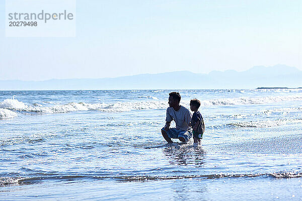 Asiatische Familie am Strand