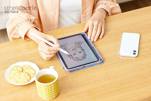 Eine Frau zeichnet mit einem Stift auf einem Tablet