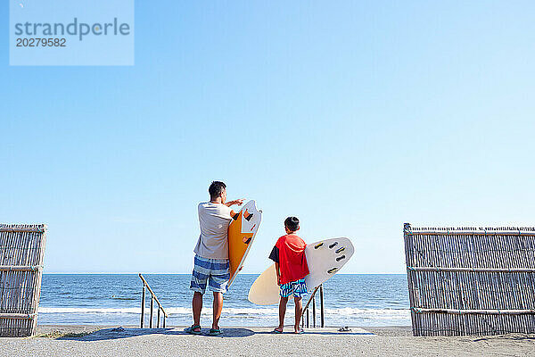 Familie mit Surfbrettern am Strand