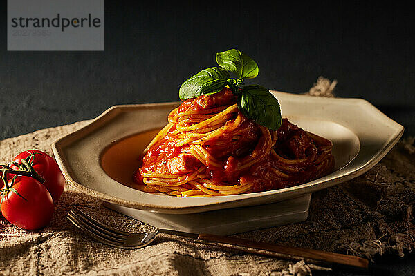 Spaghetti with tomato sauce and basil leaves on a plate