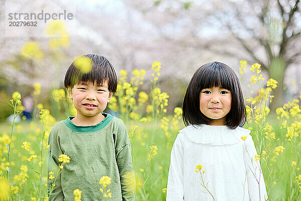 Zwei Kinder stehen auf einer Blumenwiese