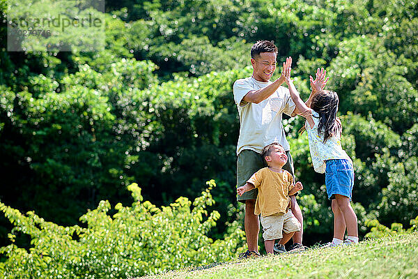 Ein Mann und zwei Kinder stehen auf einem Hügel