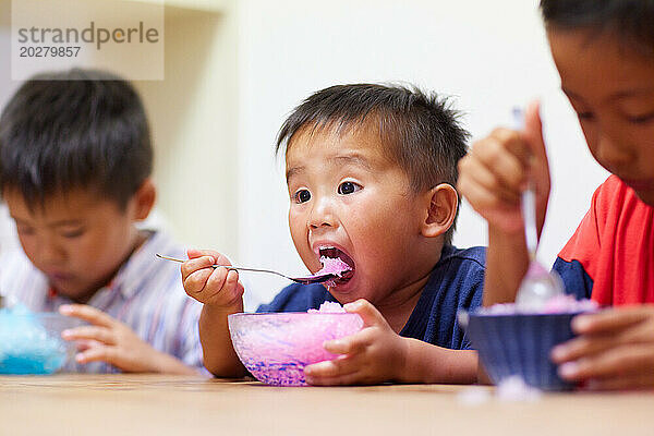 Kinder essen geschabtes Eis