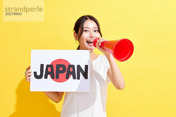 Japanerin hält ein Schild mit der Aufschrift „Japan“ und ein Megaphon