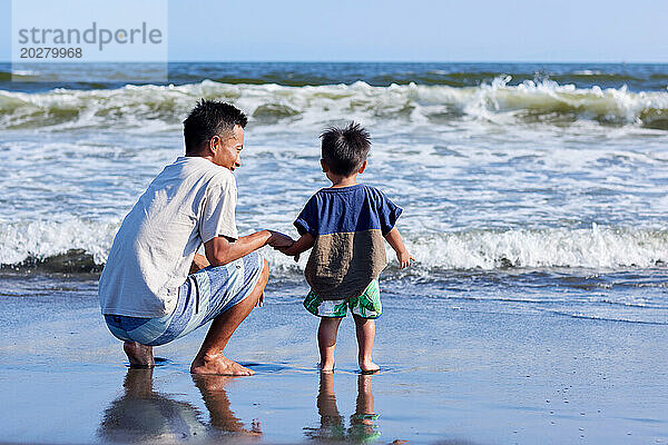 Asiatische Familie am Strand