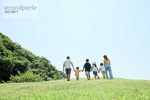 Rückansicht einer Familie  die gemeinsam im Park spaziert