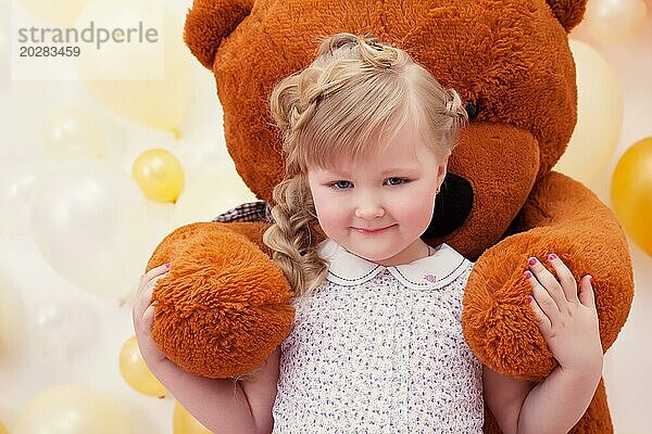 Niedliches kleines Mädchen in den Armen eines großen Teddybären  Nahaufnahme