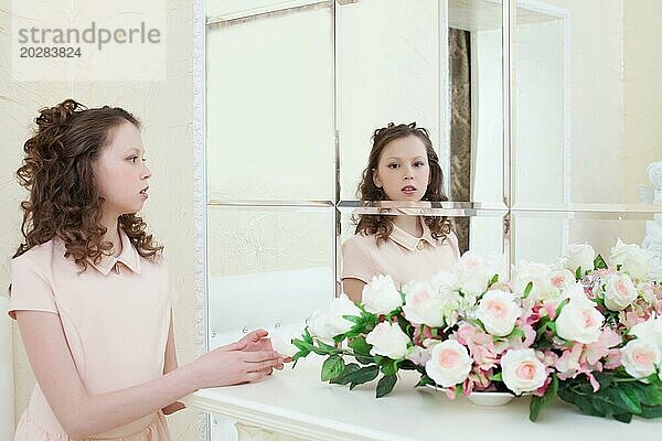 Bild von niedlichen kleinen Mädchen bewundern ihr Spiegelbild im Spiegel
