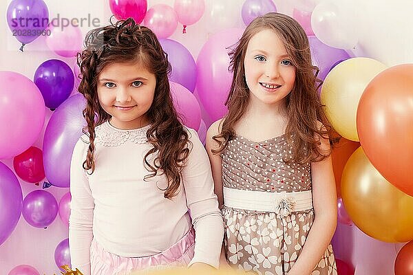 Bild von zwei fröhlichen Freundinnen posieren auf Luftballons Kulisse