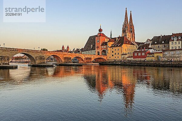 Kirche und Brücke spiegeln sich in Fluss  Abendlicht  sonnig  idyllisch  Regensburger Dom und steinerne Brücke  Regensburg  Donau  Bayern  Deutschland  Europa