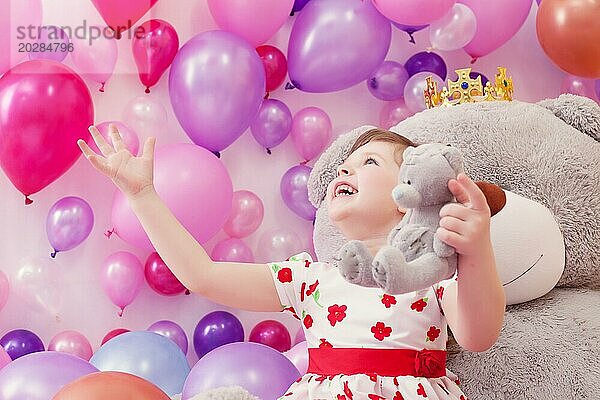 Fröhliches kleines Mädchen spielt mit Teddybären im Spielzimmer