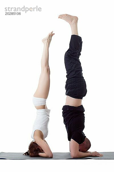 Zwei flexible Yogatrainer im Handstand