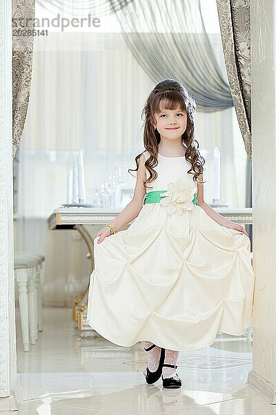 Bild der reizenden kleinen Mädchen posiert in weißen eleganten Kleid